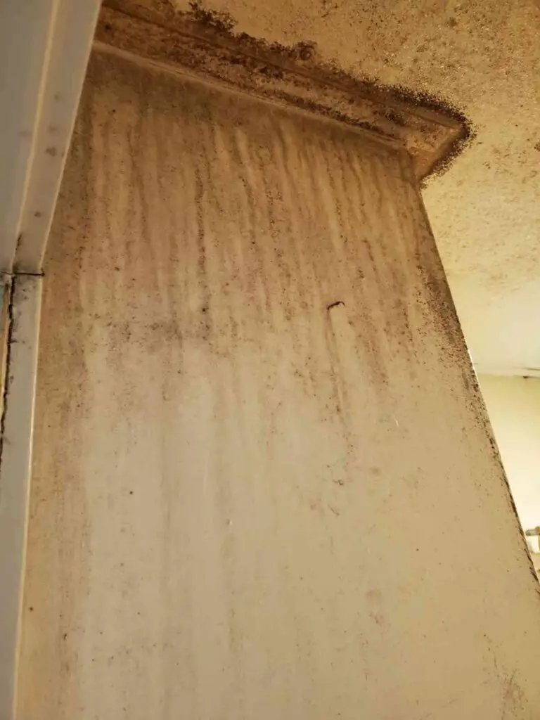 Image showing a closeup of a corner of a room with cracks and wear on the walls.