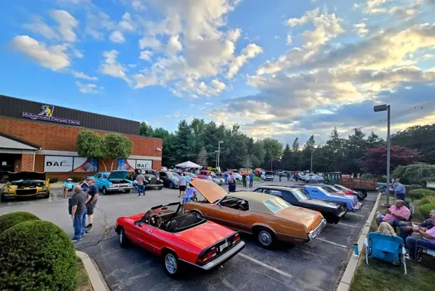 Image of DAI Cruise Nights with classic cars surrounding the community