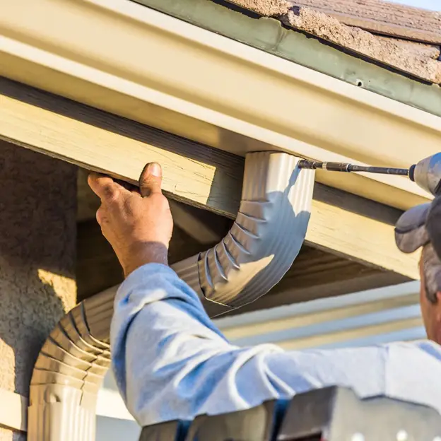 person performing maintenance on the gutter of their property