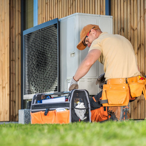 Person performing HVAC maintenance on a property