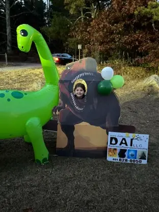 Dinosaur themed DAI cutout and inflatables posing for a picture at a local trunk-or-treat event