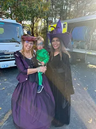 DAI employee at a Dinosaur themed DAI Truck to hand out candy at a local trunk-or-treat event