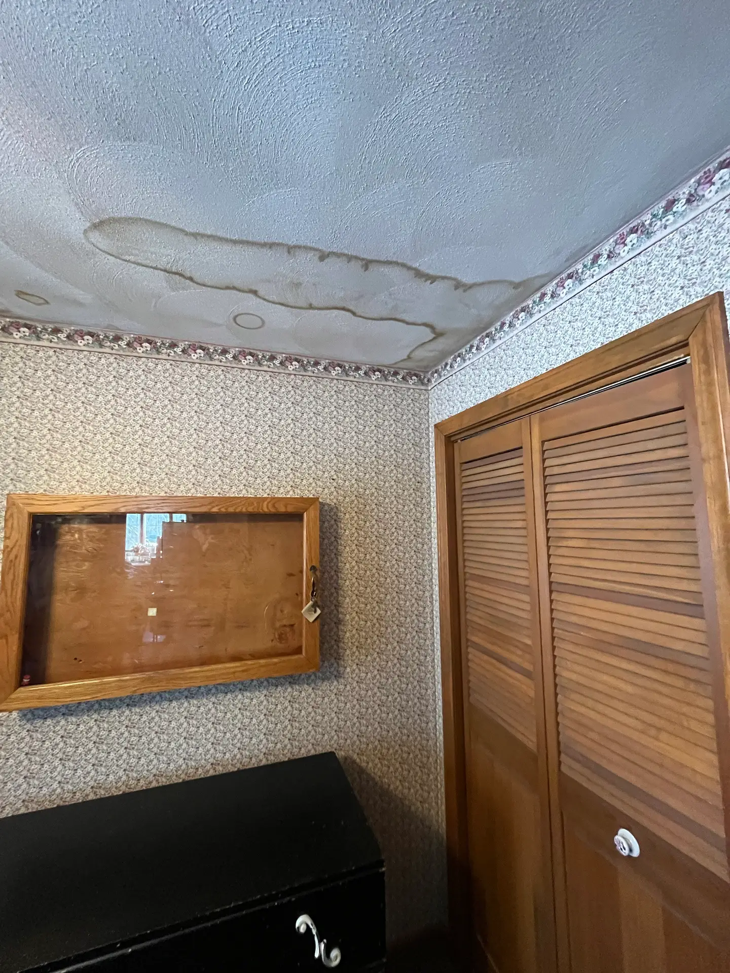 The interior of a home showing a large water stain on the ceiling referring to water damage and moisture within the home.